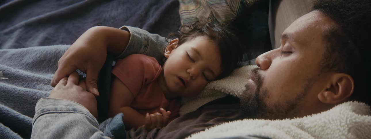 A father and daughter are taking a nap together