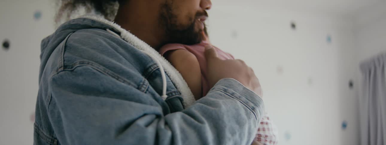 A father rocking and patting his infant on the back