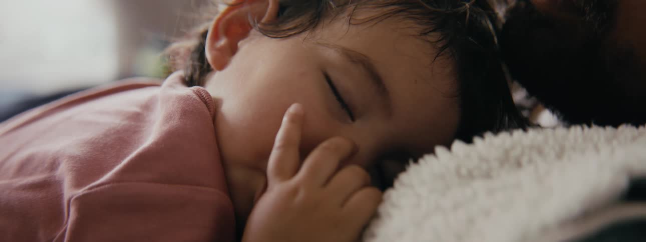 A toddler is resting and taking a nap