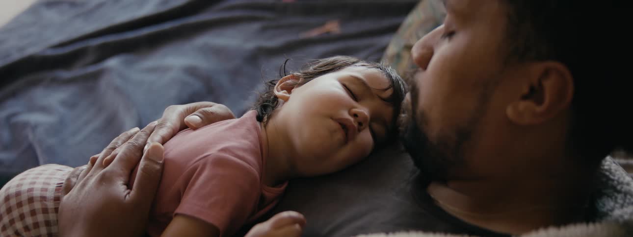 A father and daughter are taking a nap together