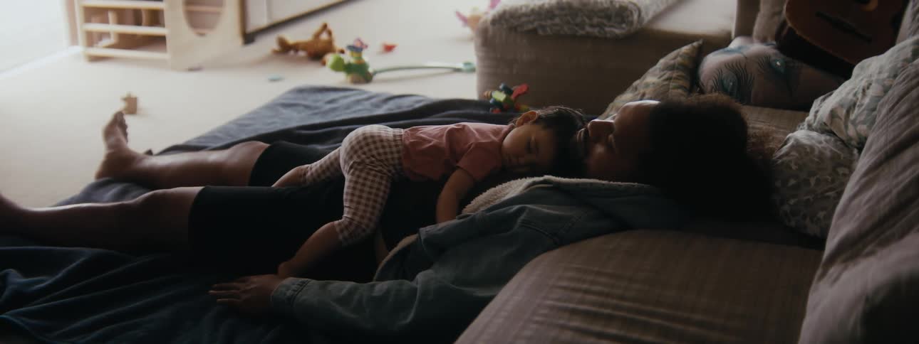 A father and daughter are taking a nap on there bed