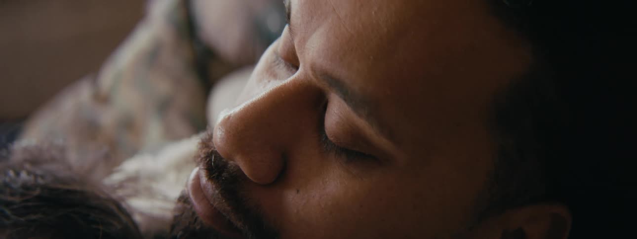 Father holds child against his chest as he dozes off