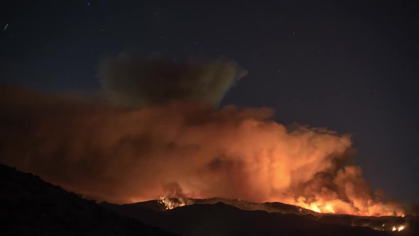 A large wildfire rages in the mountains