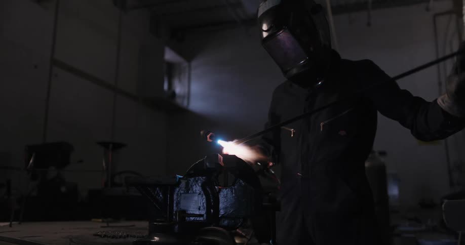 A person is wearing a helmet and holdinga flame torch