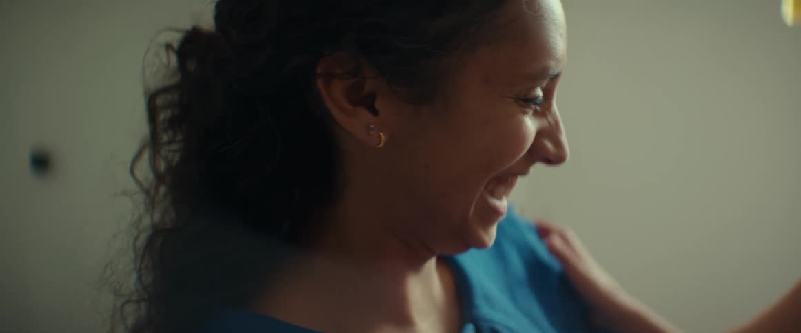 A mother smiling while her young daughter brushes her teeth
