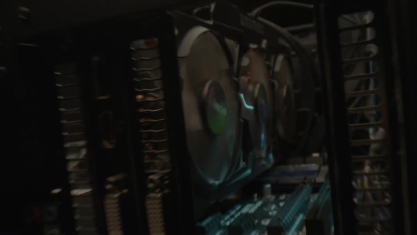 A graphics card with spinning fans and circuits inside a computer