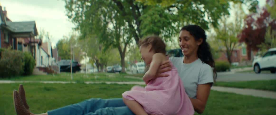 Mother and daughter are playing outdoors in the grass
