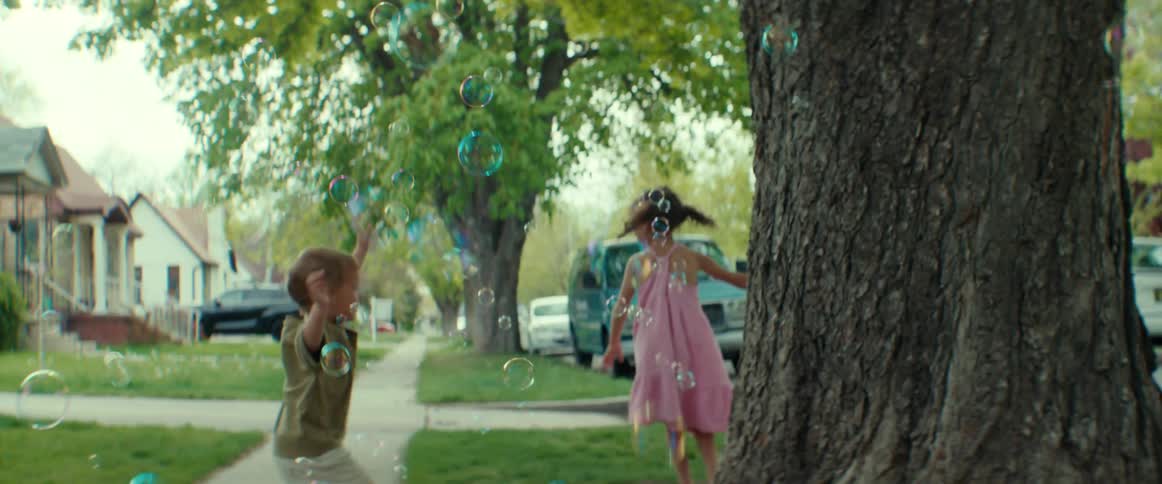 Two kids are playing outdoors in a neighborhood