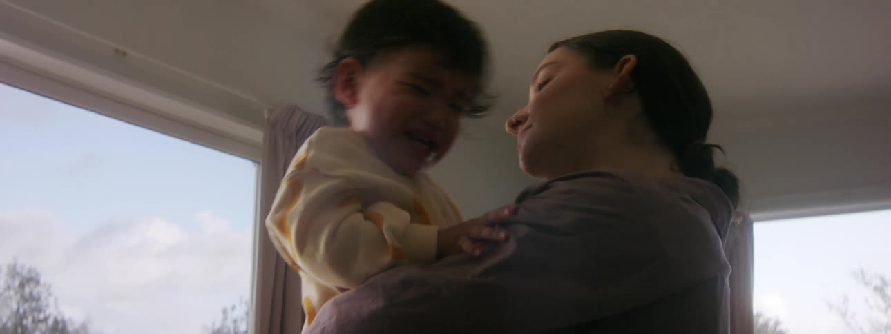 A woman attempts to calm a young girl crying in her arms