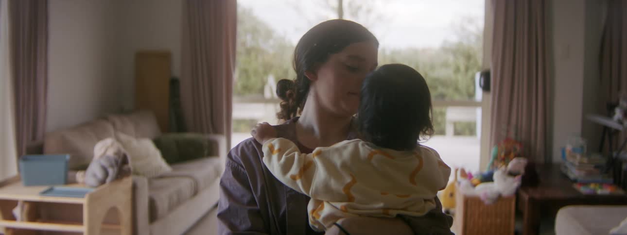 A mother is holding her daughter inside doors