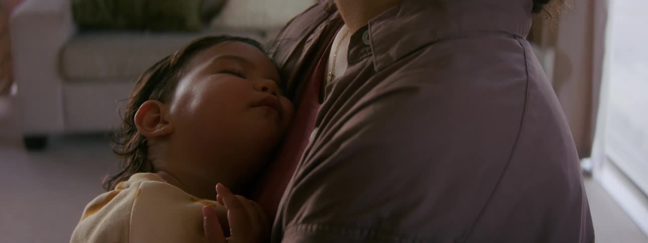 A woman rocks her baby as she sleeps