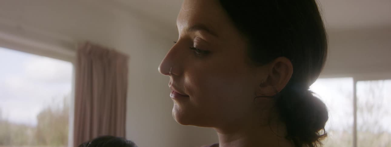 A woman is standing and holding a baby while swaying back and forth