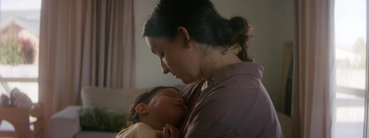A mother kisses her baby on the forehead