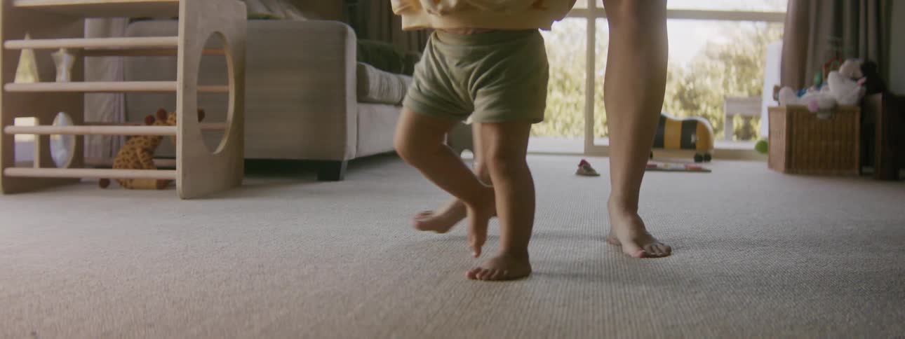 A child is being led around the carpet