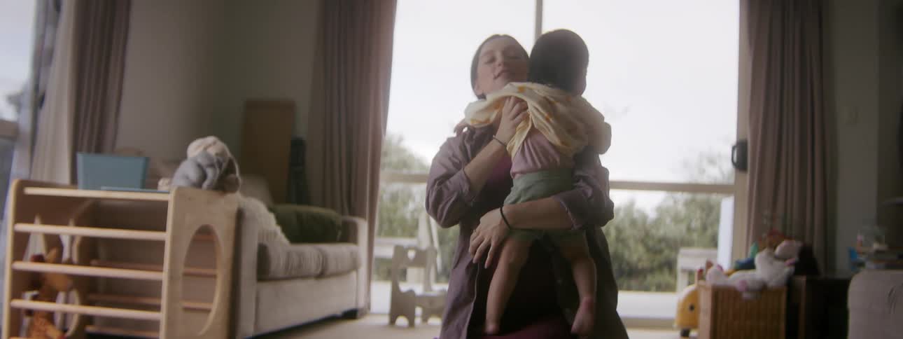 A mother lifts her daughter into her arms