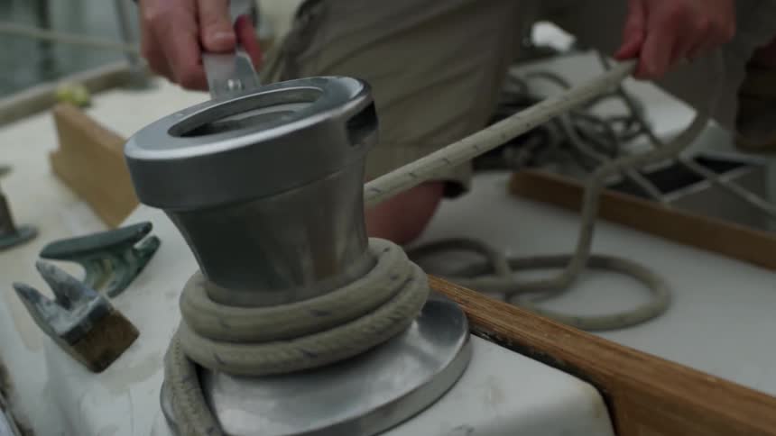 A person wraps rope around a metal object