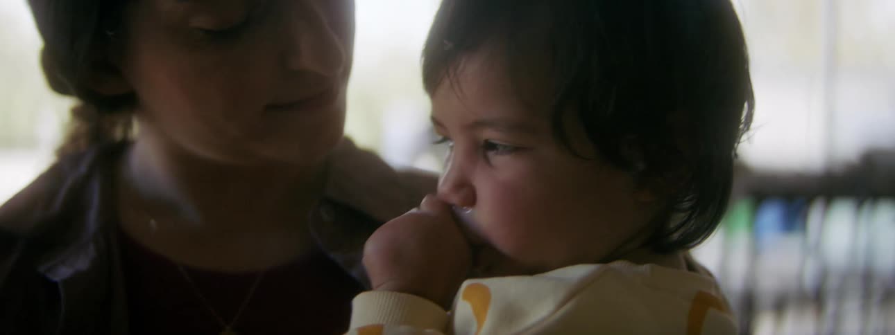 A mom holding her sleepy toddler swaying her gently