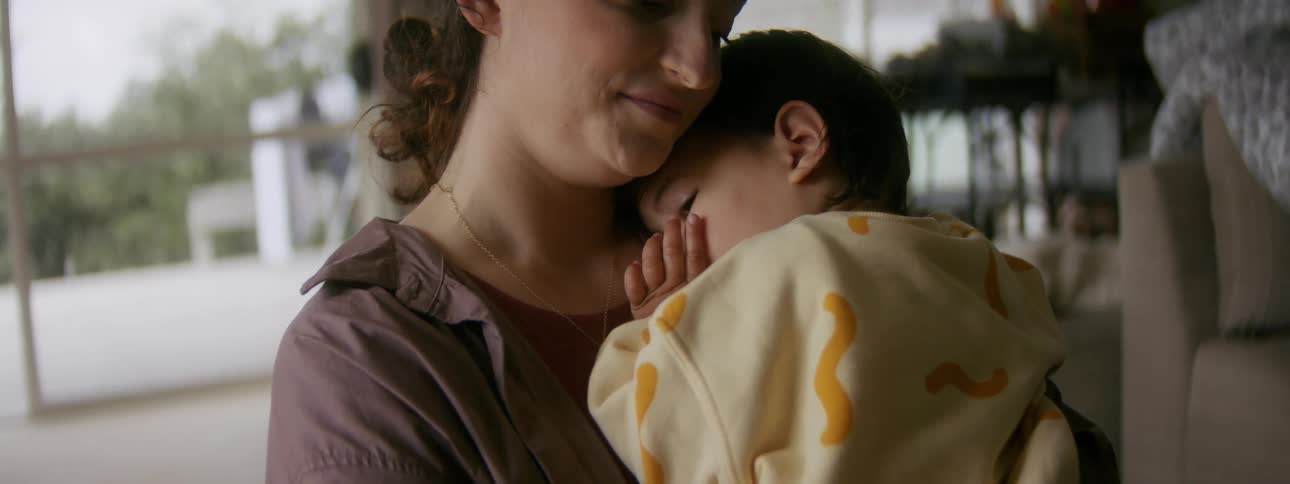A mother is holding there child inside there room