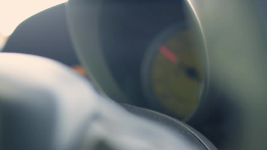 A speedometer rises and falls in a moving car