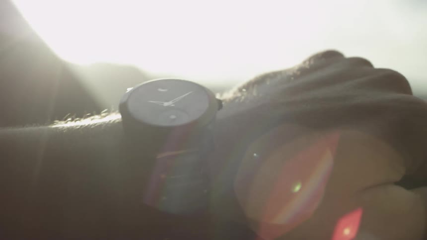 A person wearing a watch is driving a car