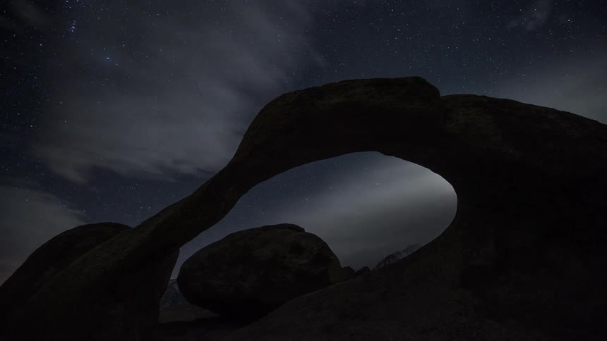 Rock formations under a cloudy sky at night