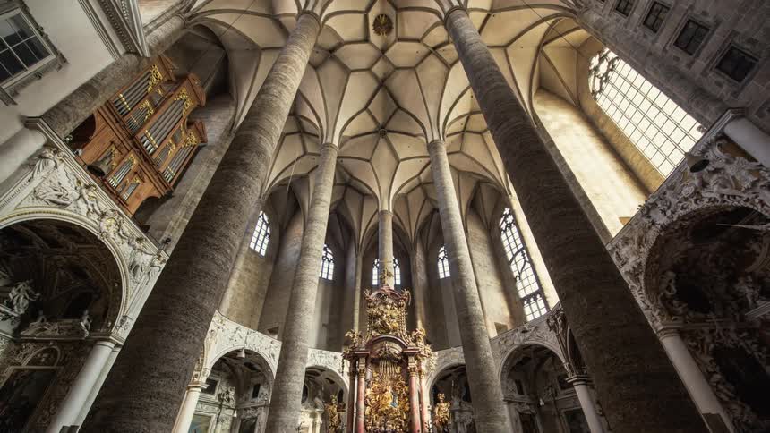 Tall columns in a church connect to a domed ceiling