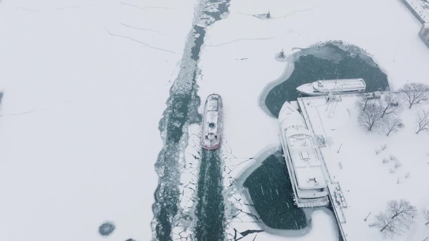 A ship breaks the ice as it enters the Chicago harbor