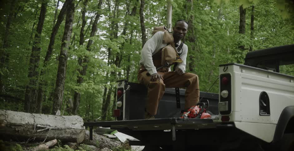 A man sitting on the back of a truck outside