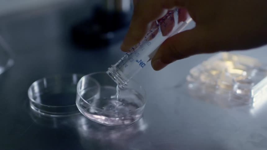 A clear liquid is poured into a dish