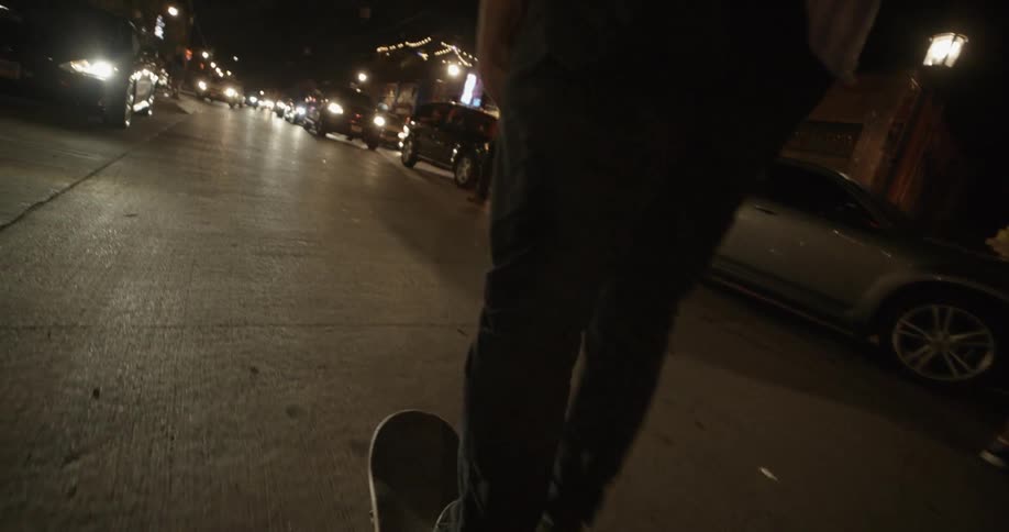 A man skateboards down a busy street