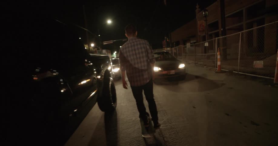 A man skateboards through traffic