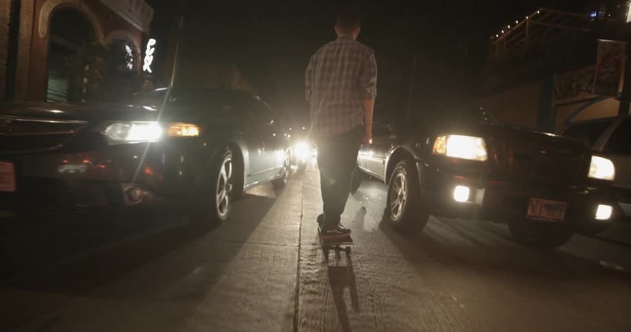 A person skateboards down a busy street