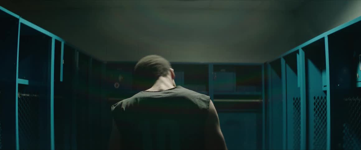 A man stretches in a locker room
