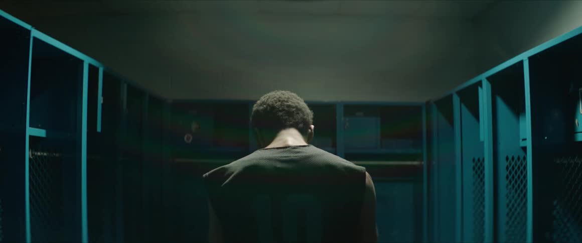 A man is bobbing his head in a locker room
