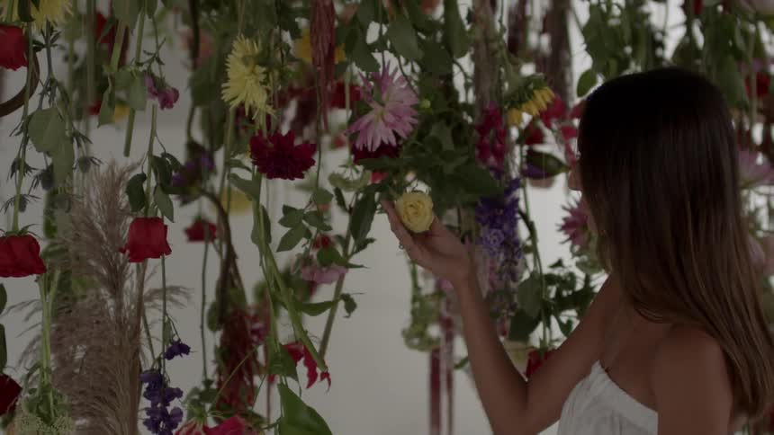 A woman looks at flowers on vines