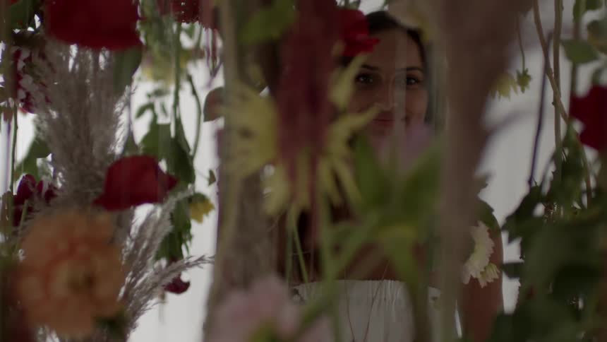 A woman standing under hanging flowers