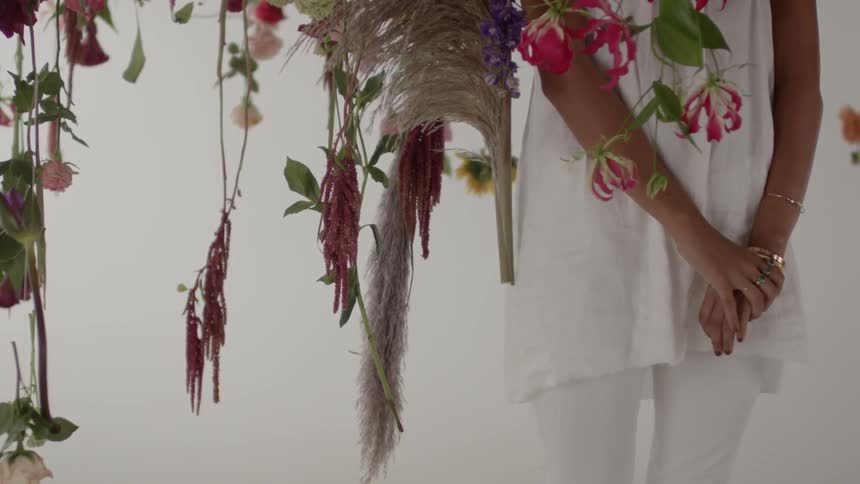 A person is standing by vines with flowers on them