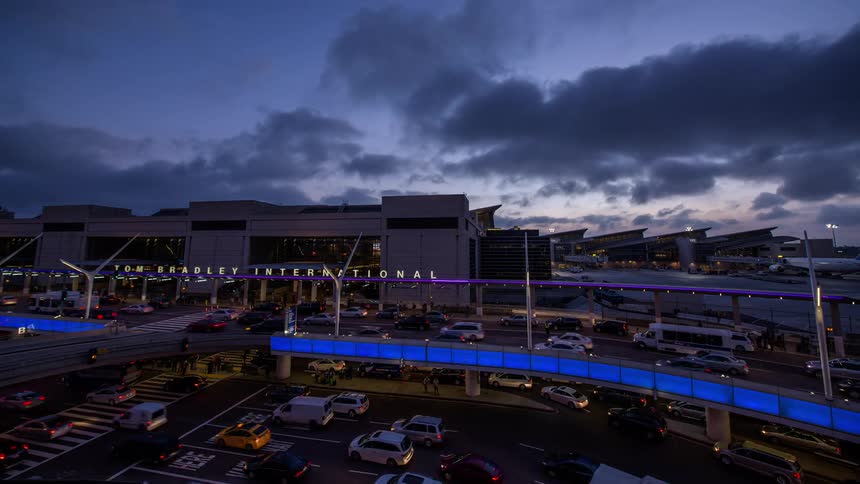 A hyperlapse shot of heavy traffic moving through LAX airport as clouds move across the sky