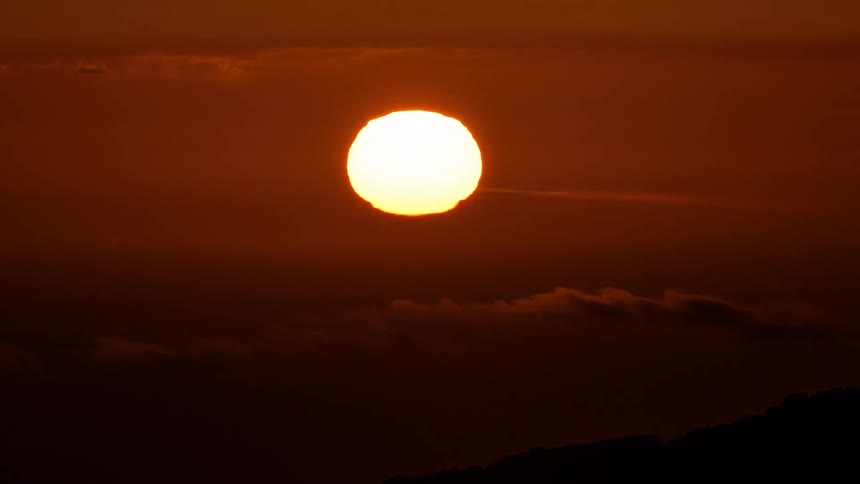 Red skies turn dark as the sun sets on the horizon