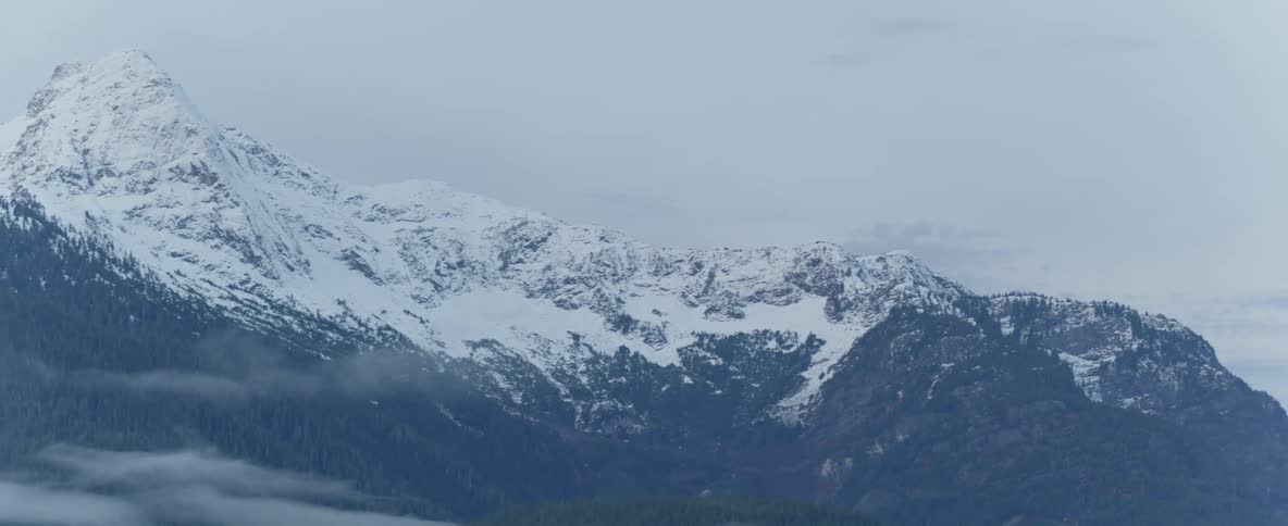 A dusting of snow covers the peaks of a mountain range