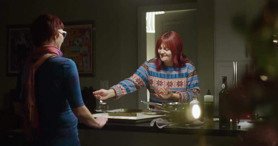 A woman sprinkles some food in a pan