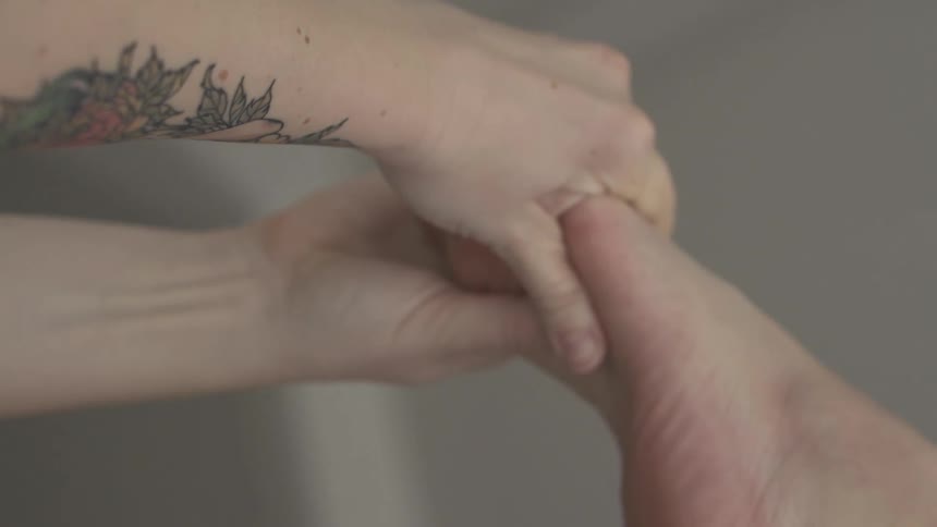 A person is holding their foot with both hands