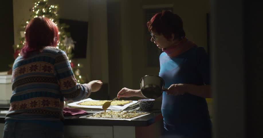 Two women are preparing food in a kitchen