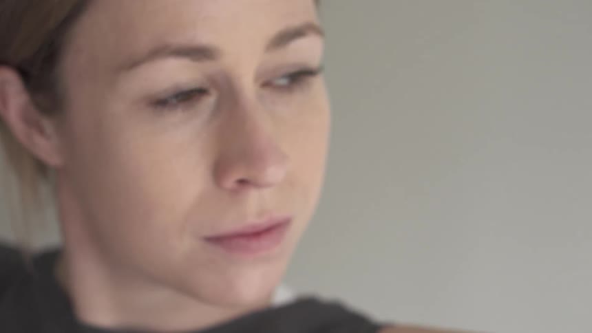 A woman blinks in a bright room