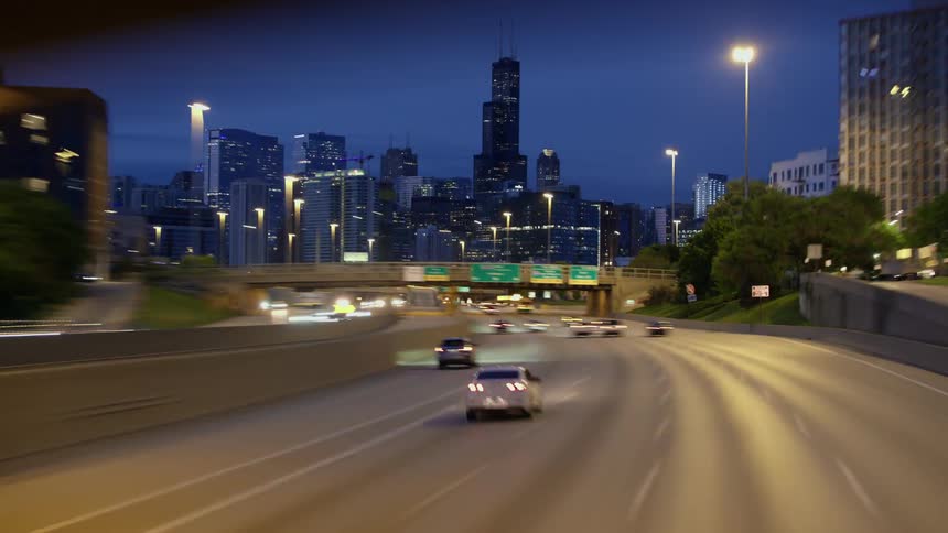 Vehicles speed down a highway headed toward downtown