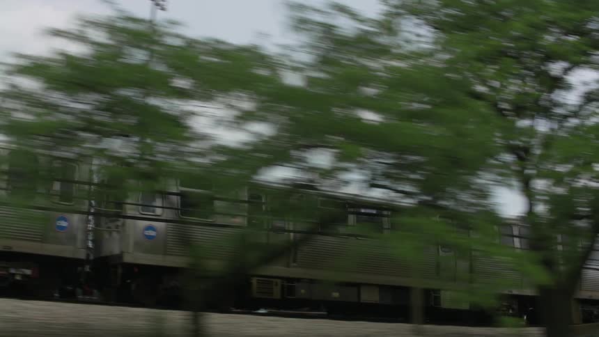 A commuter train is traveling on a cloudy day