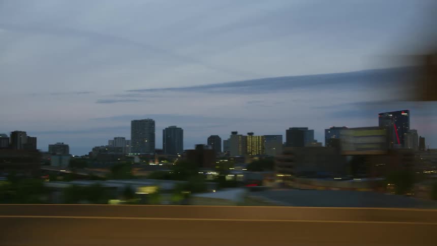 Office buildings in a city as cars drive past