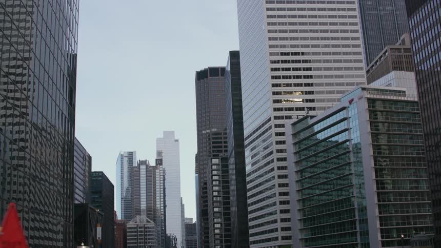 A bridge across the Chicago River is surrounded by tall buildings and skyscrapers on both sides