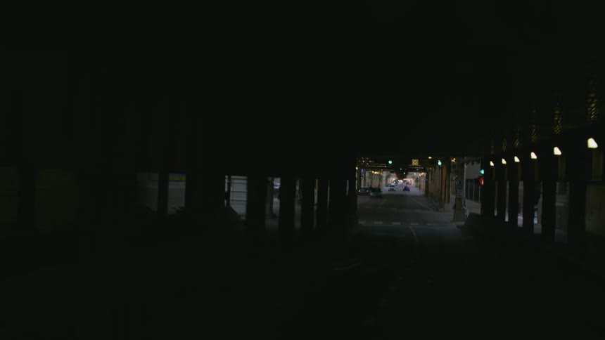 Traveling on a city street under an elevated train track turning at an intersection