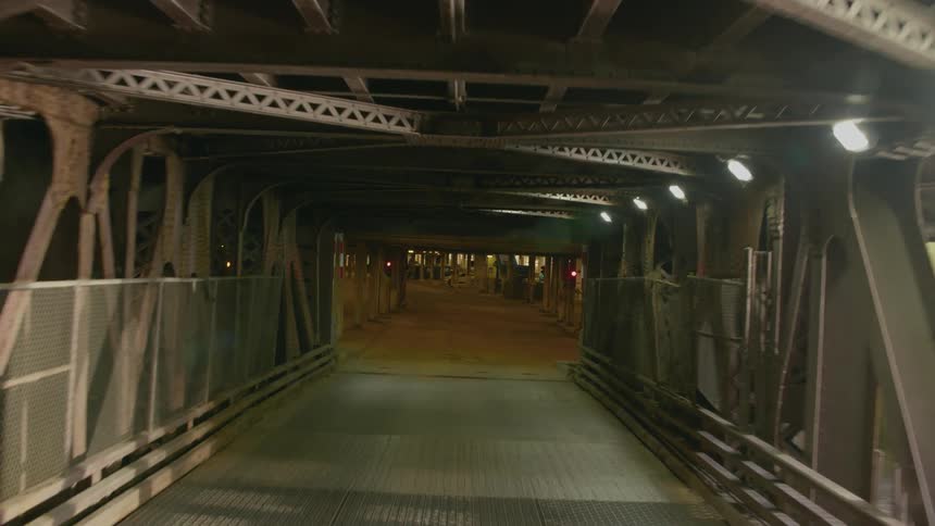 A rotating view as a vehicle drives through a tunnel under an elevated roadway